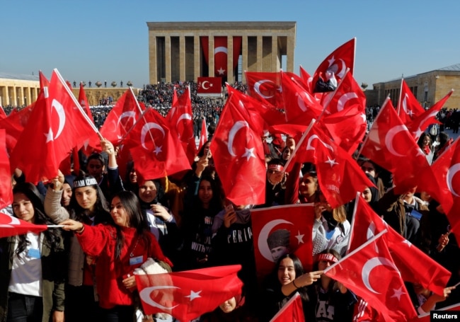 People wave Turkish flags as they attend the Republic Day ceremony at Anitkabir, the mausoleum of modern Turkey's founder Ataturk, to mark the republic's anniversary in Ankara, Turkey, Oct. 29, 2018.
