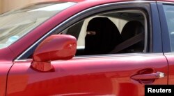 FILE - A woman drives a car in Saudi Arabia, Oct. 22, 2013.