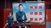 FILE - A Chinese honor guard member walks past a poster of Chinese leader Xi Jinping near the entrance to the Forbidden City in Beijing, Sept. 18, 2021. 