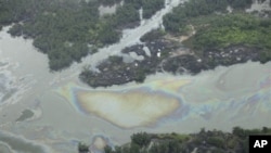 Oil is seen on the creek water's surface near an illegal oil refinery in Ogoniland, outside Port Harcourt, in Nigeria's Delta region.