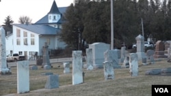 Behind these tombstones in a Christian cemetery is the house that serves as the synagogue for the Postville Jewish community. (G. Flakus/VOA)