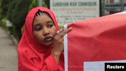 FILE - A campaigner from "#Bring Back Our Girls" hold a banner during a rally calling for the release of the Chibok school girls who were abducted by the Boko Haram militants, outside the Cameroon Embassy in Abuja.