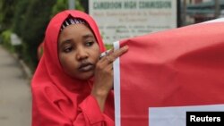 FILE - A campaigner from "#Bring Back Our Girls" hold a banner during a rally calling for the release of the Chibok school girls who were abducted by the Boko Haram militants, outside the Cameroon Embassy in Abuja, October 17, 2014.