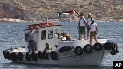Supporters of a Gaza-bound flotilla wave a Palestinian flag as one of the flotilla's boats "Juliano" departs from Perama port near Athens for a town on the southern Greek coast, July 6, 2011