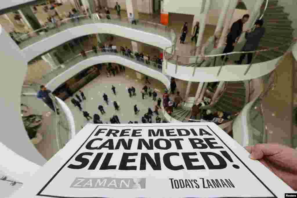 A Zaman journalist holds up a banner at the headquarters of the Zaman daily newspaper in Istanbul, Turkey, Dec. 14, 2014.