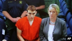 FILE - A video monitor shows school shooting suspect Nikolas Cruz, left, making an appearance before Judge Kim Theresa Mollica in Broward County Court, Thursday, Feb. 15, 2018, in Fort Lauderdale, Florida.