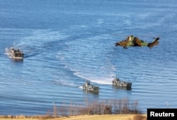 FILE _ Landing craft and a helicopter are seen during NATO's Exercise Trident Juncture, off the Trondheim coast, Norway, Oct. 30, 2018.