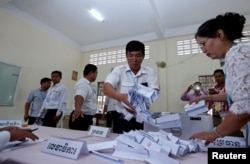 FILE - Members of the National Election Committee (NEC) count ballots during a senate election in Phnom Penh, Cambodia, Feb. 25, 2018.