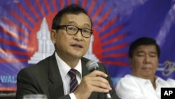 Cambodian opposition leader Sam Rainsy, left, who is currently living in exile in France, talks about the opposition's plans for 2013 elections in Cambodia during the launching of the International Parliamentary Committee for Democratic Elections in Cambodia with Philippine Sen. Franklin Drilon Monday, Sept. 10, 2012, in San Juan, east of Manila, Philippines.