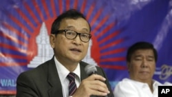 Cambodian opposition leader Sam Rainsy, left, who is currently living in exile in France, talks about the opposition's plans for next year's elections in Cambodia during the launching of the International Parliamentary Committee for Democratic Elections in Cambodia with Philippine Sen. Franklin Drilon Monday, Sept. 10, 2012, in San Juan, east of Manila, Philippines. Rainsy, who is planning to go back to Cambodia before the July 2013 elections in Cambodia, is leading the opposition and enlisting several parliamentarians from neighboring southeast Asian nations as well as other Asian countries to push for "clean and democratic" elections in Cambodia.