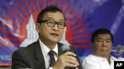 Cambodian opposition leader Sam Rainsy, left, who is currently living in exile in France, talks about the opposition's plans for next year's elections in Cambodia during the launching of the International Parliamentary Committee for Democratic Elections in Cambodia with Philippine Sen. Franklin Drilon, file photo. 