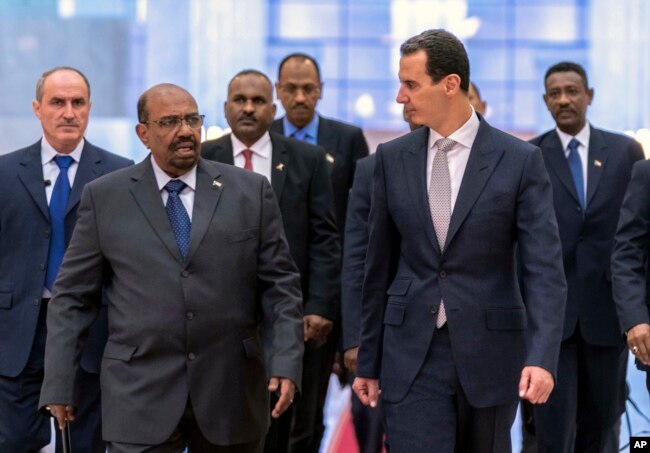 FILE - In this photo released by the Syrian official news agency SANA, Dec. 16, 2018, Syrian President Bashar Assad, right, meets with Sudan's President Omar Bashir in Damascus, Syria.