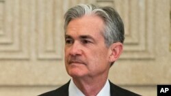 FILE - Federal Reserve Gov. Jerome Powell talks with others before a Board of Governors meeting in Washington, Nov. 30, 2015.