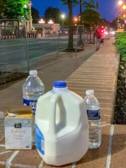 İnsanların göz yaşartıcı gazın etkisini azaltmak için Washington'da sokağa bırakılan süt ve su şişeleriyle karbonat.