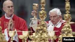 Pope Benedict XVI (R) flanked by Cardinal Tardisio Bertone conducts the holy mass of Pentecost Sunday in Saint Peter's Basilica at the Vatican, May 27, 2012. 