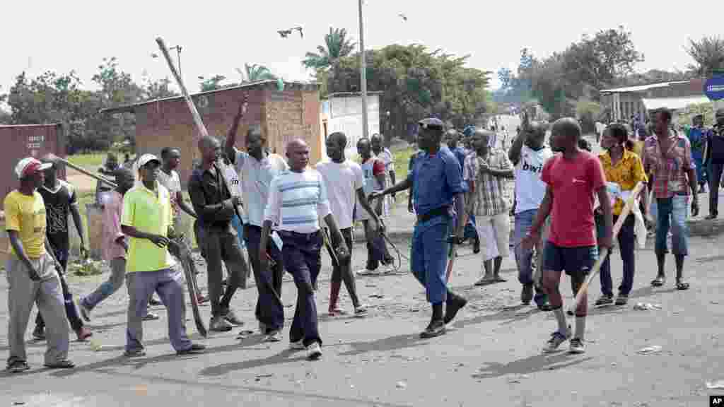 Abarwanyi bagizwe n’imikanganra y’Imbonerakure ishigikiye Reta bariko bahiga abari mu myiyerekano, igipolisi kirorera, muri Komine Kinama ku murwa mukuru w’Uburundi, Bujumbura, ku musi wa mbere, italiki 25 z’ukwezi kwa gatanu, umwaka w’2015.