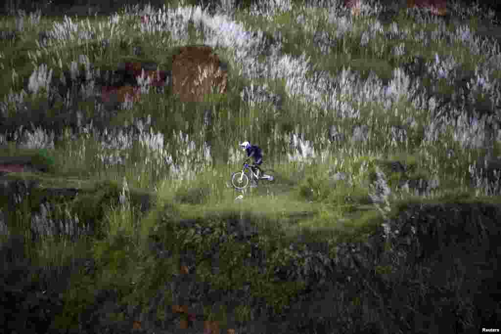 A youth rides a bicycle on the hills in Kathmandu, Nepal.