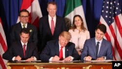 FILE - President Donald Trump sits between Canada's Prime Minister Justin Trudeau, right, and Mexico's President Enrique Pena Nieto as they sign a new United States-Mexico-Canada Agreement that is replacing the NAFTA trade deal, Nov. 30, 2018.