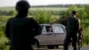 Ukrainian soldiers stop a vehicle at a checkpoint outside the town of Amvrosiivka, eastern Ukraine, close to the Russian border, June 5, 2014.
