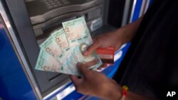 A man shows new Venezuelan bank notes he withdrew from a cash machine in Caracas, Venezuela, Aug. 21, 2018. 