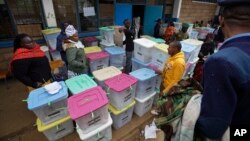 Electoral workers stand by ballot boxes stacked up at a collection center in Nairobi, Aug. 9, 2017. 