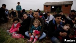Syrian refugees who crossed the Evros river, the natural border between Greece and Turkey, rest on a field as they wait for the police to arrive and transfer them to a first reception center, near the village of Nea Vyssa, Greece, May 2, 2018.