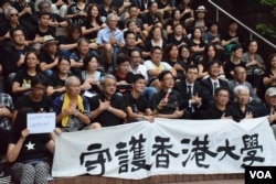 約100名港大校友及社會人士在港大校園集會，以手語表達「守護港大」。(美國之音湯惠芸)