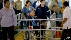 El expresidente Alberto Fujimori sale en silla de ruedas de la clínica en la que estaba internado en Lima, Perú. Le acompaña su hijo, Kenji (chaqueta azul).