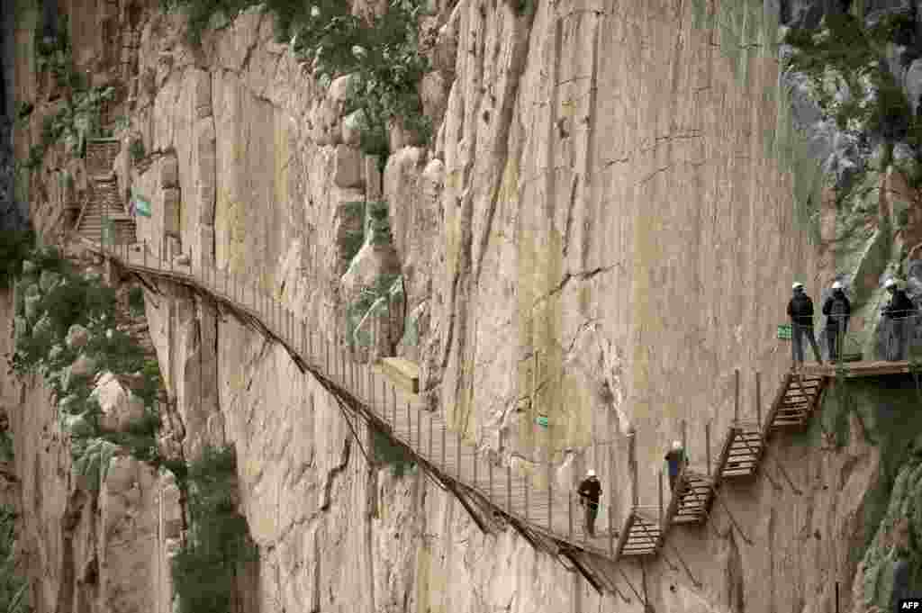 Journalists walk during a visit to the foot-path &quot;El Caminito del Rey&quot; (King&#39;s little path) a narrow walkway hanging and carved on the steep walls of a defile in Ardales near Malaga, Spain, March 15, 2015. The one meter-wide and 7.7 km-long path, hanging from Ardales&#39; defile at 100 meters high, was closed in the mid 90&#39;s after several hikers lost their lives.