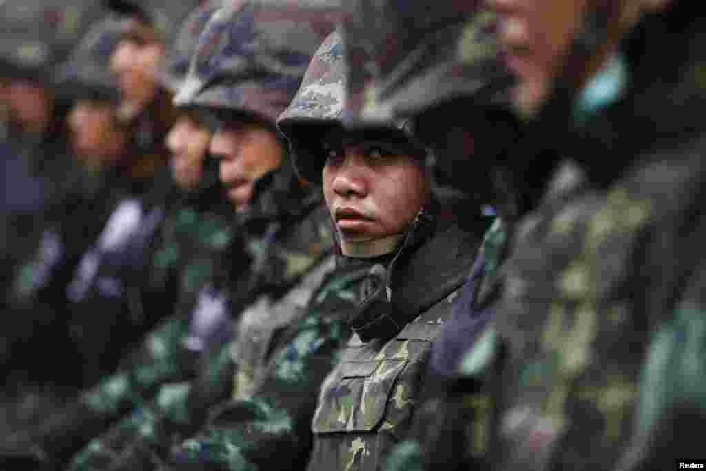 Soldiers stand guard as anti-government protesters gather at a defense ministry compound, Bangkok, Feb. 19, 2014.