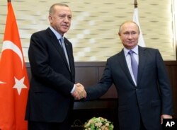 Russian President Vladimir Putin, right, and Turkish President Recep Tayyip Erdogan pose for a photo during their meeting in the Bocharov Ruchei residence in the Black Sea resort of Sochi, Russia, Tuesday, Oct. 22, 2019.