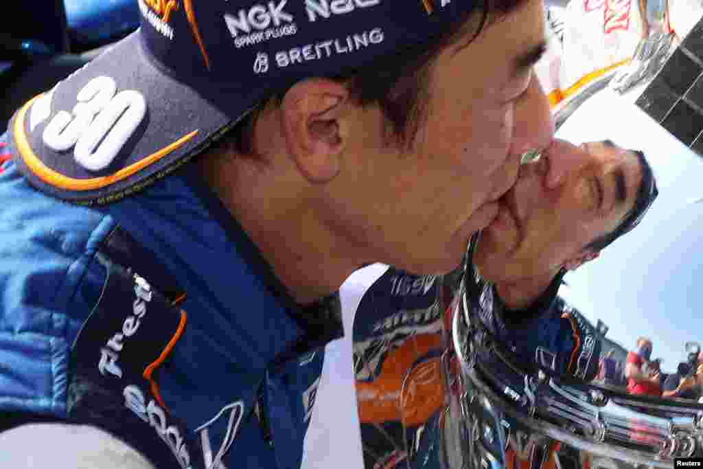 IndyCar driver Takuma Sato kisses the Borg-Warner Trophy after winning the 2020 Indianapolis 500 at the Indianapolis Motor Speedway in Indiana.