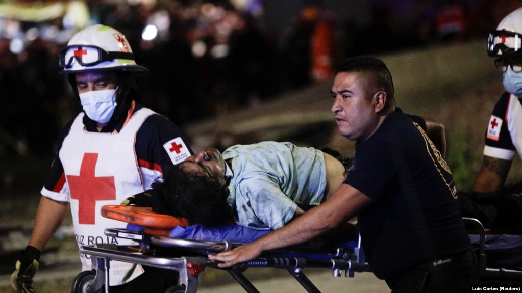 Des secouristes transportent une personne blessée sur une civière après l'effondrement partiel d'un viaduc de métro sur lequel se trouvaient des wagons à la station Olivos de Mexico, au Mexique, le 3 mai 2021.
