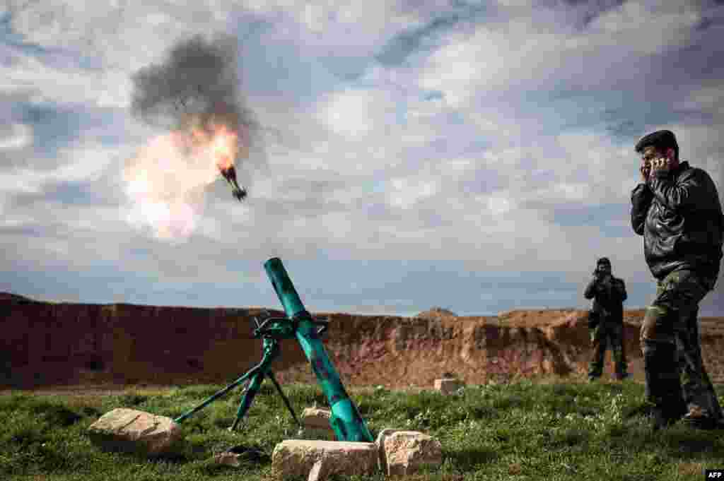 Syrian rebels fire a mortar towards regime forces stationed at Kwiriss airport in Al-Bab, 30 kilometers from the northeastern Syrian city of Aleppo. 