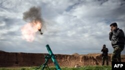 FILE - Syrian rebels fire a mortar towards regime forces stationed at Kwiriss airport in Al-Bab, 30 kilometers from the northeastern Syrian city of Aleppo, February 14, 2013. 