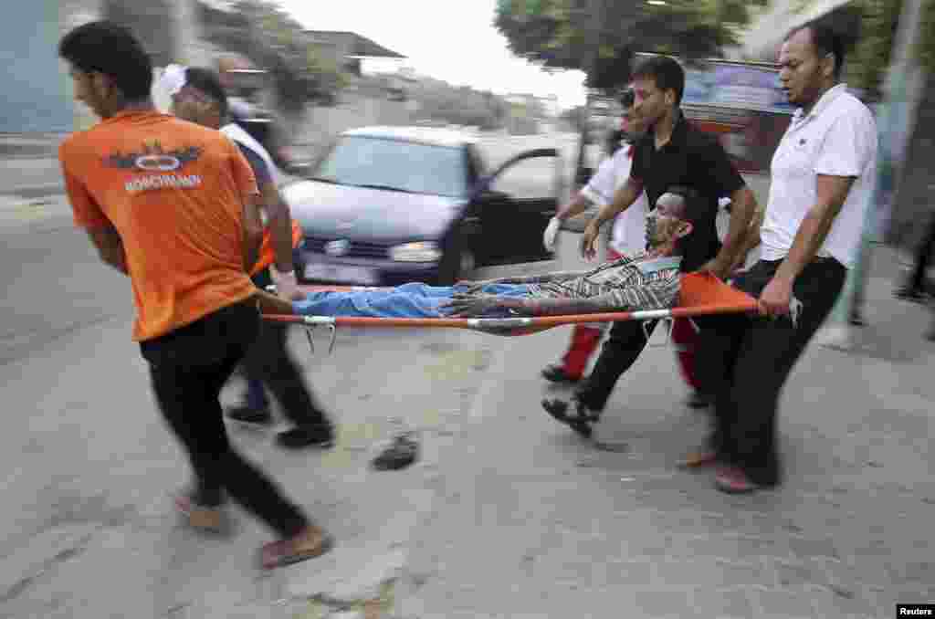 Palestinians evacuate a man medics said was wounded by Israeli shelling during an Israeli ground offensive east of Khan Younis in the southern Gaza Strip, July 24, 2014. 