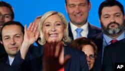 FILE - French far right leader Marine Le Pen, center, waves on stage next to other populist leaders at the end of a May Day meeting in Nice, south of France, May 1, 2018.