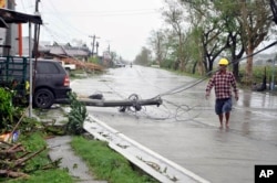 FILE - A resident walks on the highway after Typhoon Yutu slammed Isabela province in northeastern Philippines, Oct. 30, 2018.