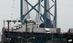 Trucks cross the Ambassador Bridge from Windsor, Ontario, into Detroit, June 12, 2018.