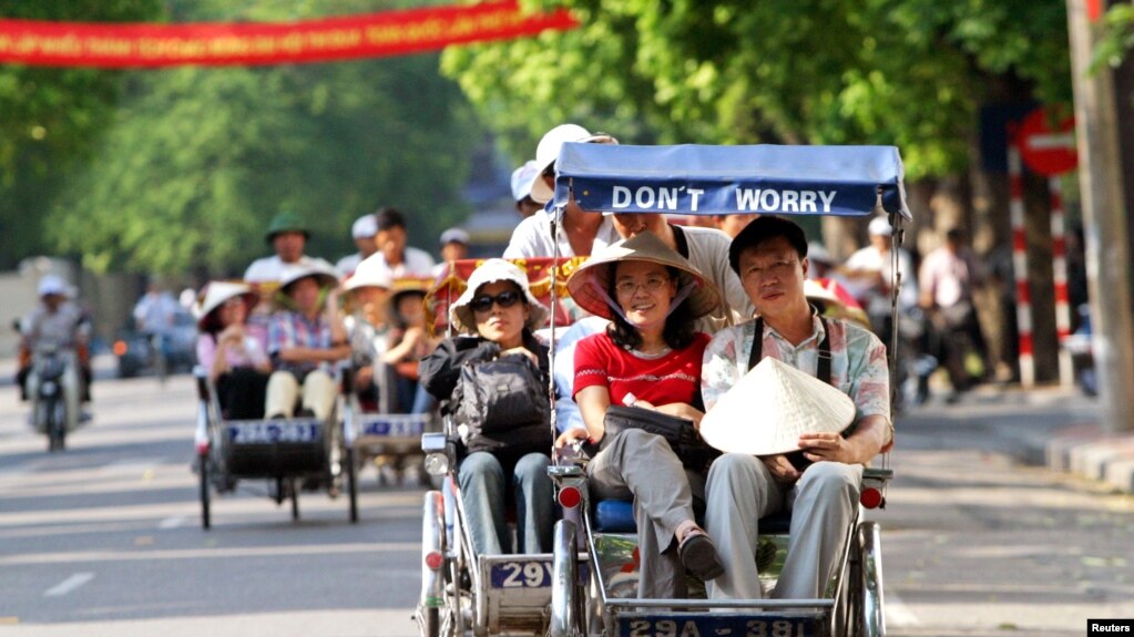 Khách du lịch Trung Quốc đi xích lô ở Hà Nội. Khách từ quốc gia láng giềng phương Bắc tới Việt Nam tăng gần 50% so với năm trước, chiếm gần 1/3 lượng khách quốc tế tới Việt Nam trong năm nay.