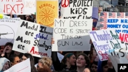 Crowds of people hold signs on Pennsylvania Avenue at the "March for Our Lives" rally in support of stricter gun control, March 24, 2018, in Washington.