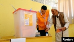 Seorang pria mencelupkan jarinya ke dalam tinta sebelum memberikan suaranya dalam pemilu parlemen di Al Bayda, Libya (25/6).