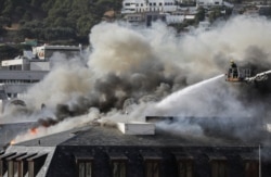 Firefighters work at the parliament as the fire flared up again, in Cape Town, South Africa, January 3, 2022. REUTERS/Sumaya Hisham