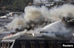 Firefighters work at the parliament as the fire flared up again, in Cape Town, South Africa, January 3, 2022. REUTERS/Sumaya Hisham
