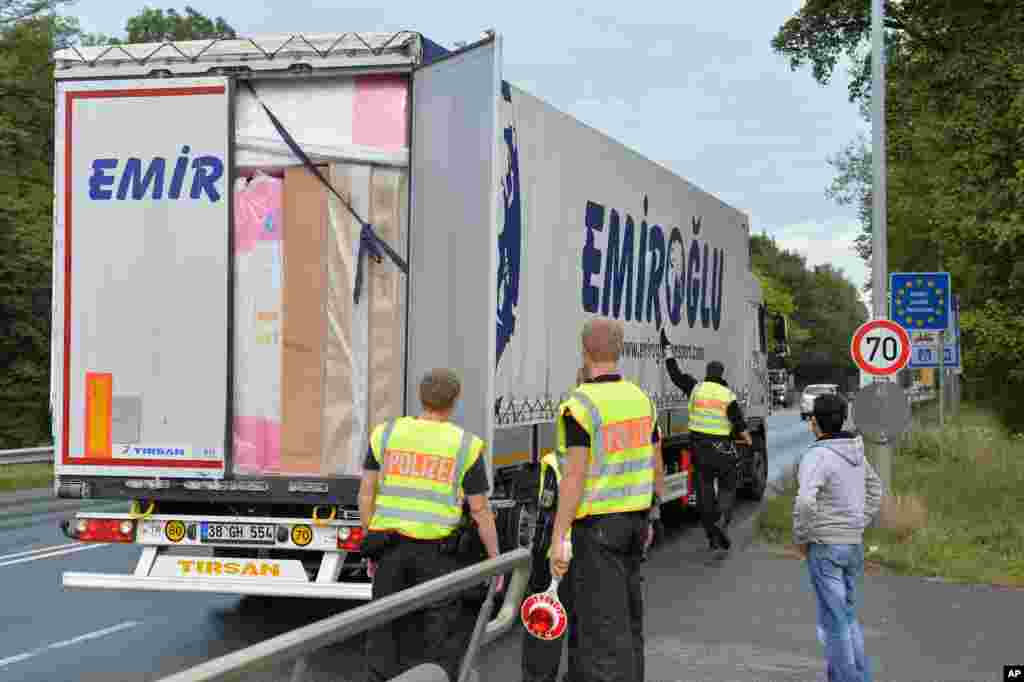 Policemen check vehicles on a country road to Freilassing, in Salzburg, Austria. Germany introduced temporary border controls Sunday to stem the tide of thousands of refugees streaming across its frontier, sending a clear message to its European partners that it needs more help with an influx that is straining its ability to cope.