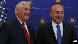 U.S. Secretary of State Rex Tillerson, left, and Turkey's Foreign Minister Mevlut Cavusoglu stop for photographers prior to their meeting in Ankara, March 30, 2017.