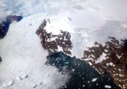 FILE - In this file photo dated Thursday, Aug. 3, 2017, a glacier at left calves icebergs into a fjord off the Greenland ice sheet in southeastern Greenland. (AP Photo/David Goldman, FILE)