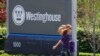 На фото: жінка проходить повз знак у штаб-квартирі компанії Westinghouse у США, 2014 рік