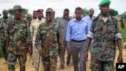 Somalian President Sharif Sheikh Ahmed [2nd L with stick] walks with officials and army commanders of the Somalian transitional government at the front line in Deynile district, in Somalia's capital Mogadishu, October 24, 2011.