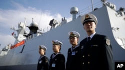 FILE - In this Dec. 7, 2016, photo, Chinese Navy officials stand in front of the ship Daqing, in San Diego. China has appointed the former head of its southern fleet as the new commander of its increasingly powerful navy. Vice Adm. Shen Jinlong takes command of a sprawling force that is growing in both size and modernity as China seeks to assert its regional maritime claims and project strength far from its shores.